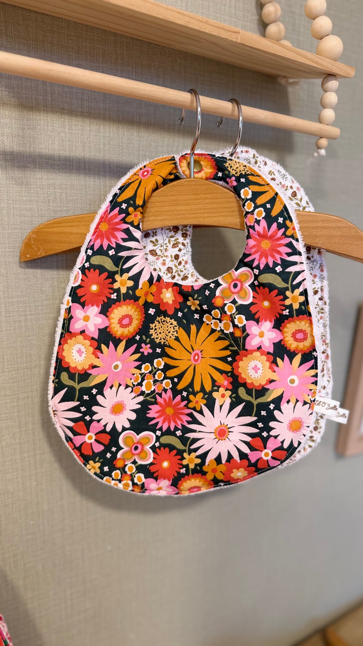 Bavoir bébé Lunelle à grosses fleurs rétro roses et orange sur fond noir