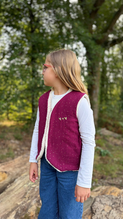 Petite fille portant un gilet sans manche enfant en double gaze framboise, en extérieur
