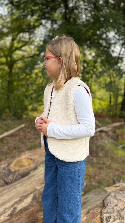 Petite fille portant un gilet sans manche enfant côté sherpa écru, en extérieur