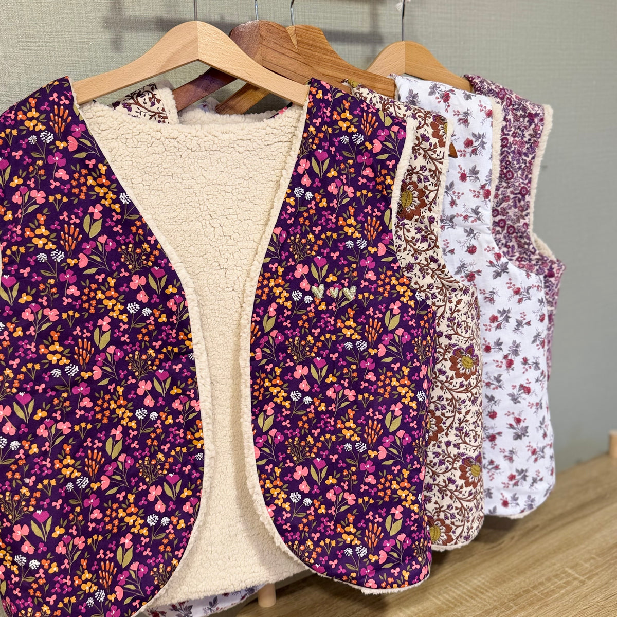 Gilets sans manche femme fleuris doublés sherpa sur portant, collection faite main Lil'O'Zelle