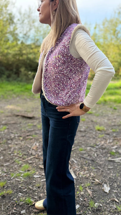 Femme de profil portant un gilet sans manche fleuri violet doublé sherpa