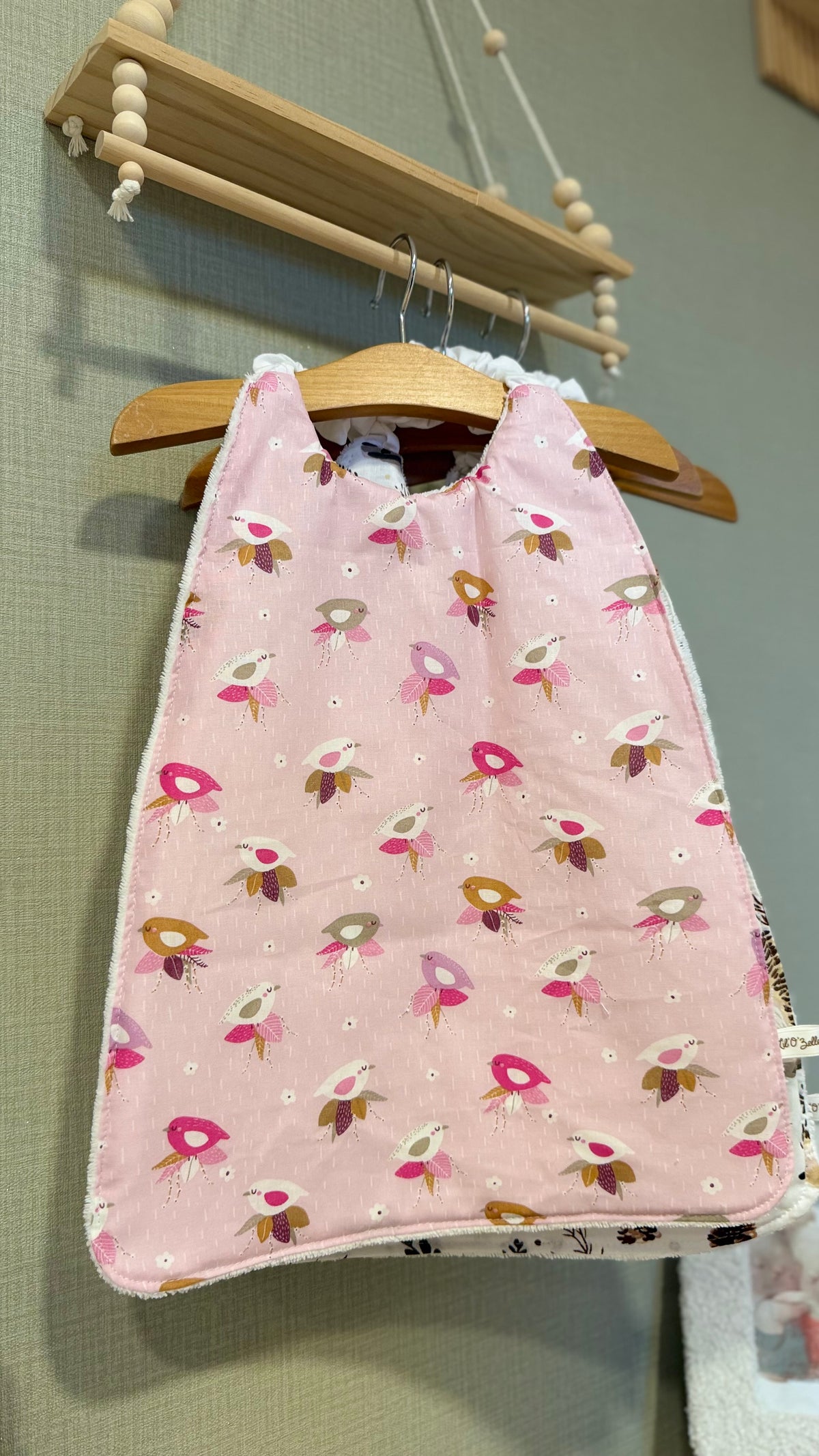 Grand bavoir maternelle Zouzou motif petits oiseaux roses sur fond rose pâle