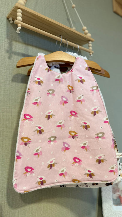 Grand bavoir maternelle Zouzou motif petits oiseaux roses sur fond rose pâle