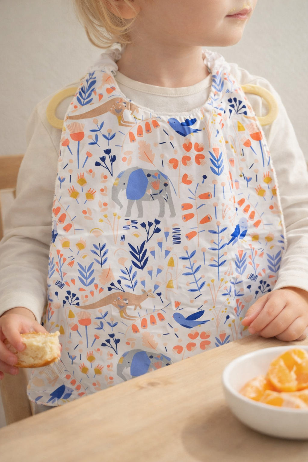 Bavoir maternelle à encolure élastique porté par un enfant à table, fait main par Lil'O'Zelle