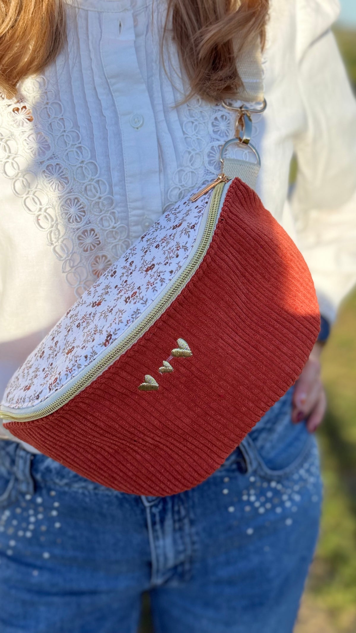 Sac banane Lovia en velours côtelé rouge brique, rabat fleuri écru et cœurs dorés brodés