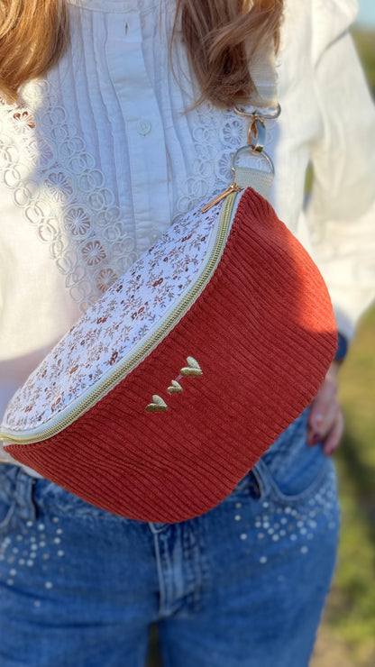 Sac banane Lovia en velours côtelé rouge brique, rabat fleuri écru et cœurs dorés brodés
