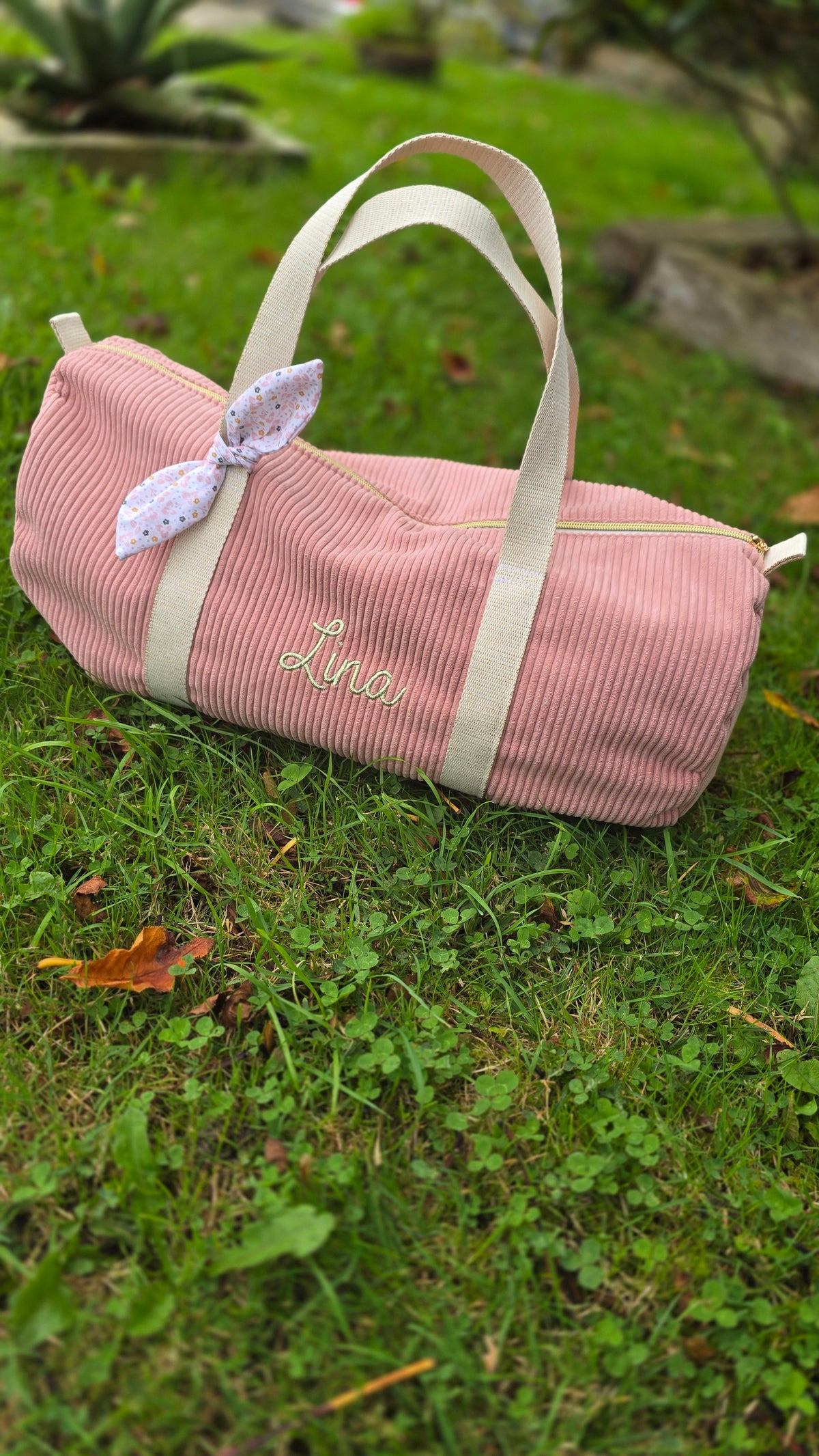 Sac polochon bébé personnalisé, velours rose avec nœud fleuri, en extérieur