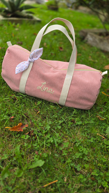 Sac polochon bébé personnalisé, velours rose avec nœud fleuri, en extérieur